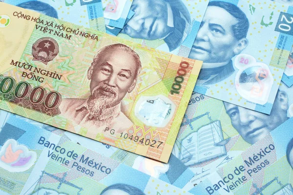 Närbild Vietnamesisk Tio Tusen Dong Sedel Bakgrund Mexikanska Tjugo Peso — Stockfoto