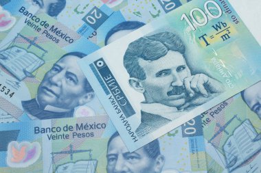 Meksika 'daki 20 pezoluk banknotun arka planında mavi-beyaz, 100 Sırp dinar banknot.