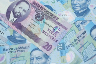 Mozambik 'ten gelen mor, yirmi metik banknotun yakın plan resmi. Meksika' da 20 pezoluk banknotların arka planında.