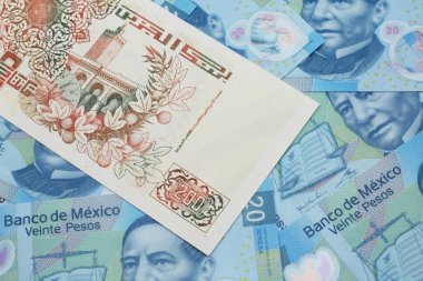 Meksika 20 pesosunun arka planında 200 dinar değerinde bej bir Cezayir banknotunun makro görüntüsü.