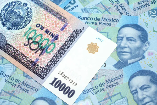 墨西哥20比索绿色钞票背景下的1万张乌兹别克索姆钞票的缩影 — 图库照片