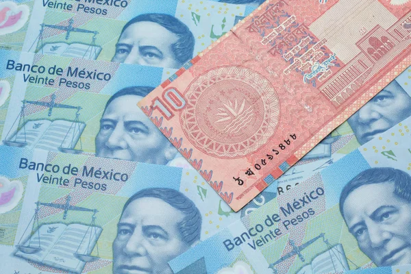 一张来自孟加拉国的红色 十塔卡的钞票在墨西哥20比索的宏观钞票上的近照 — 图库照片