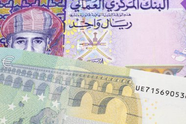 Umman 'dan çok renkli bir riyal notu, makroyu mavi ve yeşil 5 Euro ile kapatın.