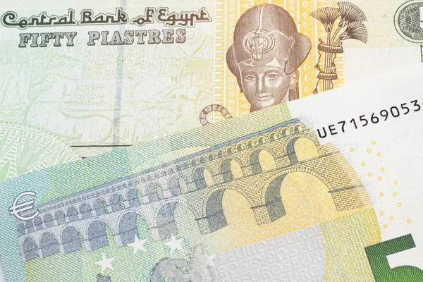 一张五彩缤纷的五十张埃及披头士钞票的特写图片与一张蓝色和绿色的欧洲五张欧元钞票在宏观层面上的特写 — 图库照片