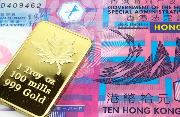 A macro image of a colorful ten dollar bill from Hong Kong with a gold bar.  Shot close up.