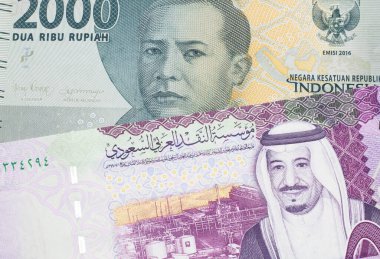 İçinde beş Suudi riyal notu olan gri bir Endonezya rupiah banknotu. 