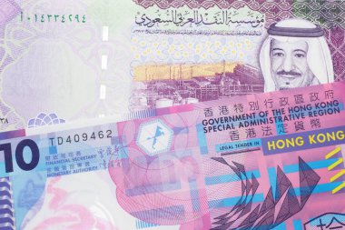 Renkli bir 10 dolarlık Hong Kong banknotu makroda renkli, Suudi Arabistan 5 riyal banknotuyla çekilmiş.