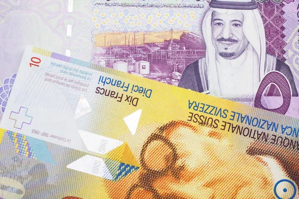 Żółty Dziesięć Franków Szwajcarskich Pięcioma Banknotami Banku Centralnego Arabii Saudyjskiej — Zdjęcie stockowe