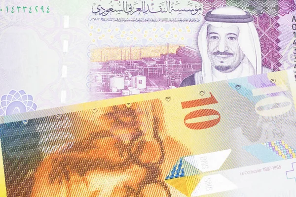 Żółty Dziesięć Franków Szwajcarskich Pięcioma Banknotami Banku Centralnego Arabii Saudyjskiej — Zdjęcie stockowe