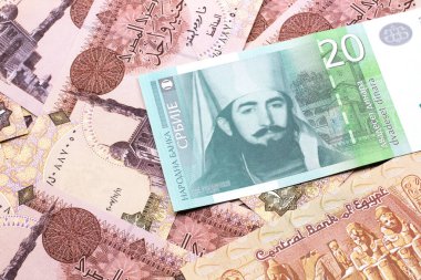 Mısırlı bir banknotun arka planında yeşil-beyaz, yirmi Sırp dinarı banknota yakın plan.