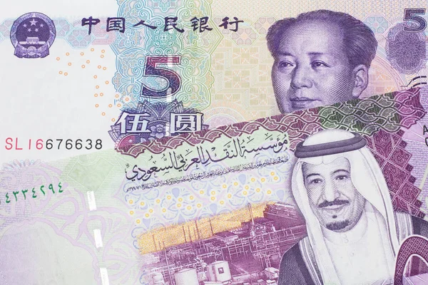 A close up image of a five riyal note from Saudi Arabia along with a five yuan bank note from the People\'s Republic of China