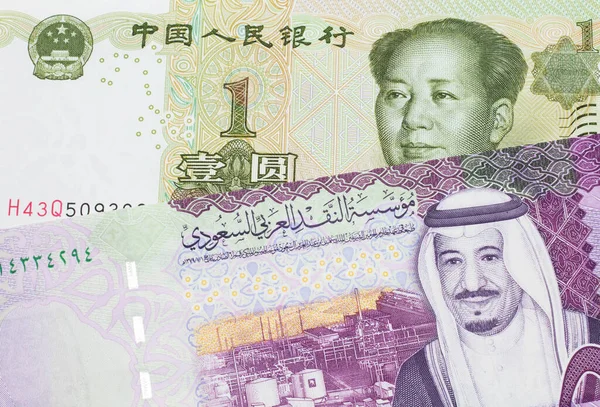 A close up image of a five riyal note from Saudi Arabia along with a one yuan bank note from the People\'s Republic of China