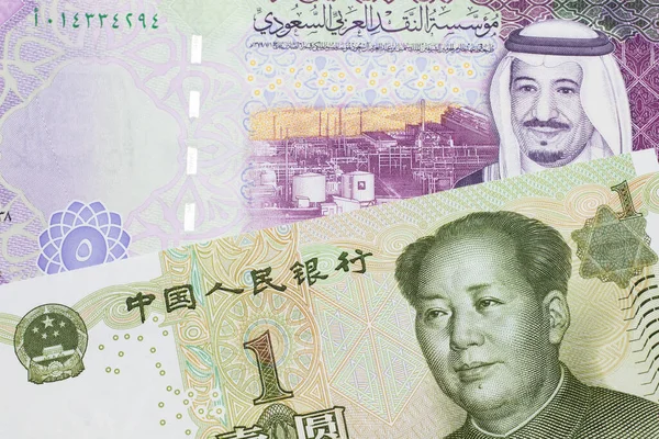 A close up image of a five riyal note from Saudi Arabia along with a one yuan bank note from the People\'s Republic of China