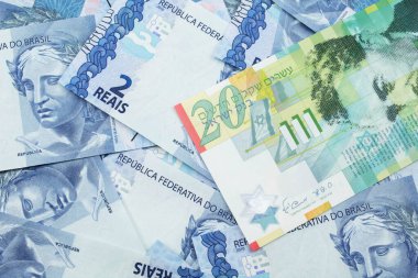 İsrail 'den gelen yirmi şekel banknotun yakın plan görüntüsü makrodaki iki Reais banknotunun arka planında.