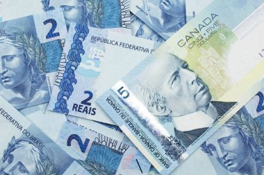 Brezilya bankasının arka planında mavi bir Kanada 5 dolarlık banknotunun makro görüntüsü.