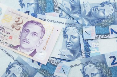 Singapur 'dan gelen iki dolarlık banknotun yakın plan görüntüsü makroda Brezilya' nın iki reais banknotuyla birlikte.