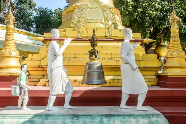 Zdjęcie, statua, miedź dzwon prowadzi przez whiterobed diakon, kulturą Mjanmy, Dec-2017 — Zdjęcie stockowe