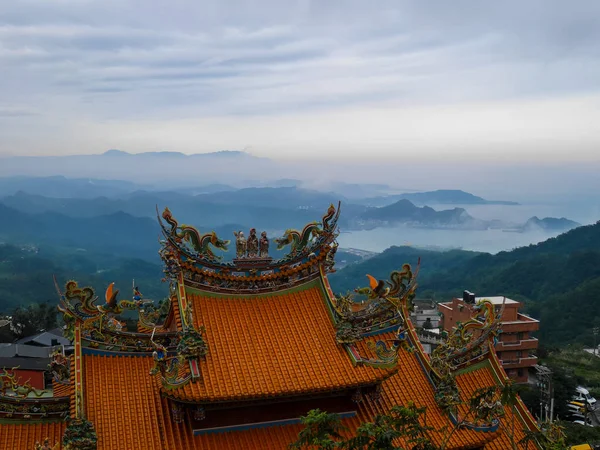 Traditional Chinese style roof in yellow with misty landscape se