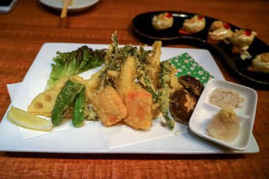 Japon beyaz kare plaka üzerinde sebze tempura dipp ile karışık.