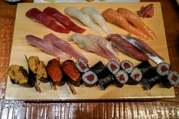 Varieties of fresh seafood sushi served on wooden platter with g — Stock Photo, Image