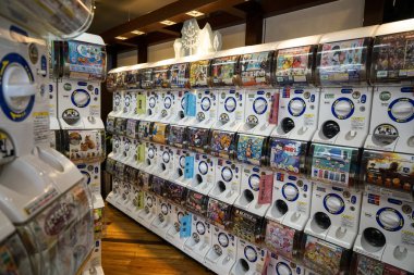 Dazaifu, Japan - May 14, 2017 : Rows of Gashapon machines, popular vending machine dispensed capsule toys showing manga character prints in a shop, Dazaifu, Fukuoka, Kyushu clipart