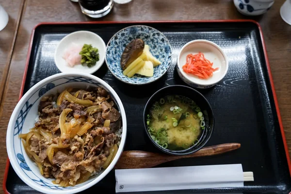 Gyudon o tazón de res, un plato popular japonés, en conjunto combinado que incluye tazón de arroz, sopa de miso, pepinillos y otros platos secundarios en el restaurante local en Yufuin — Foto de Stock