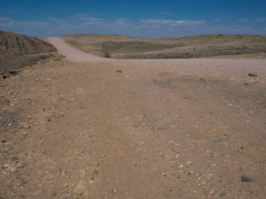 Kuru Tozlu rock dağ manzara zemin taş ve mavi gökyüzü ile Namib Çölü arka plan ile kumlu yolculuğa boşaltmak