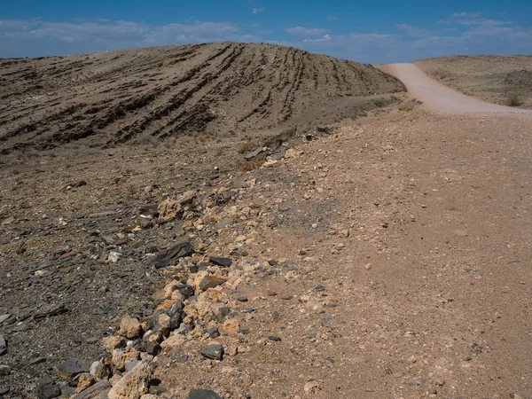 Kumlu yolculuğa yoluyla kuru tozlu rock dağ manzara zemin taş ve mavi gökyüzü ile Namib Çölü arka plan dokusu