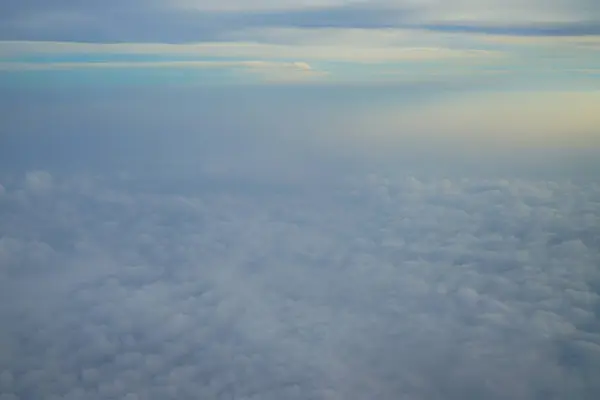 夢のような抽象的な白い雲が青い空と飛行機の窓から日の出明るい背景のビュー — ストック写真