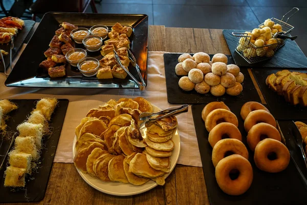 Table de petit déjeuner buffet grec avec des variétés de pâtisseries, petits pains, crêpes, beignets, gâteau au beurre, plats de bonbons locaux, etc. . — Photo