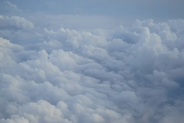 ライトブルーの色空と浮動白い雲ワンダーランドの色合いを飛行機の窓から見る — ストック写真