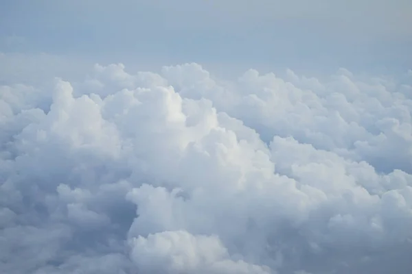 ライトブルーの色空とふわふわの柔らかい白い雲の色合いを飛行機の窓から見る — ストック写真