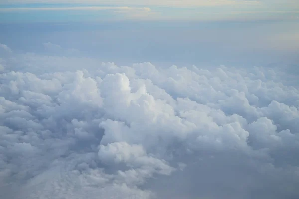 ライトブルーの色空の浮雲の素晴らしい白い色合いを飛行機の窓から見る — ストック写真