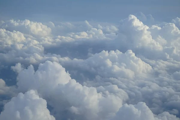 空飛ぶ飛行機の窓から青い空を背景の色合いと想像力に従って白い雲の美しいフリー フォーム ビュー — ストック写真