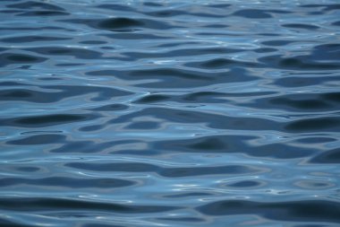 Mavi deniz suyu güzel soyut sahne dalgalanma ile güneş ışığı yansıması, degrade gölge ve gölge, seçici odak dondurucu hareket