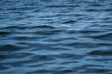 Mavi deniz suyu soyut hareket sahne dalgalanma ile güneş ışığı yansıması, degrade gölge ve gölge, seçici odak dondurucu hareket