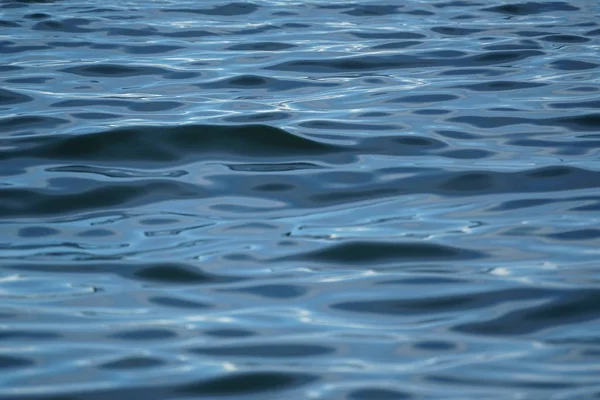 青い海の水の抽象的な波状シーン リップル太陽光の白い反射、グラデーションの陰と影、セレクティブ フォーカスと凍結の動き — ストック写真