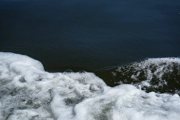 深い青色の海の Copyspace シーン光円形リップル背景を移動すると白いバブル泡水ボートを実行して、手を振っています。 — ストック写真