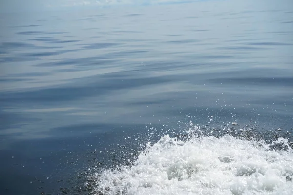 グラデーションの青い海の光の Copyspace シーンは白い泡泡水ボート、凍結の動きを実行することによって飛散と背景をリップルします。 — ストック写真