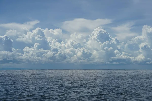 強力なフリー フォーム白い雲、青い空を背景と海の水と深い青色の海の色合いの劇的なシーンのリップルします。 — ストック写真