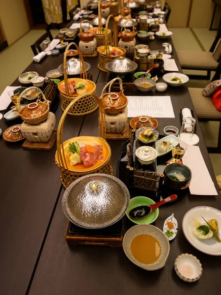 Los conjuntos de cena japoneses ryokan kaiseki sirven en una habitación privada familiar que incluye aperitivo como tofu de flor de cerezo, olla caliente y cesta de shabu de cerdo, sashimi, platos fritos y calientes y licor de ciruela. — Foto de Stock