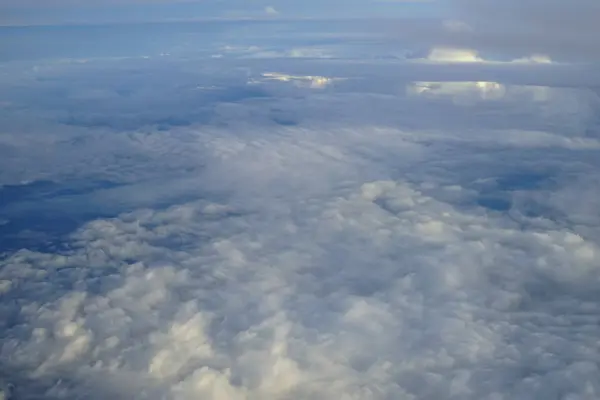 空飛ぶ飛行機の窓から青い空を背景の色合いと抽象的な柔らかい白い雲の美しいビュー — ストック写真