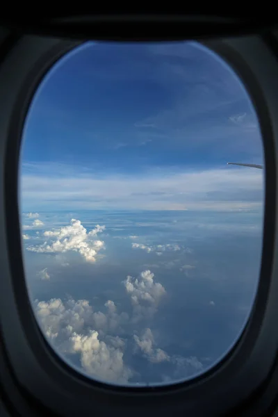 抽象的な白い雲とぼやけウィンドウ フレームを介して飛行機の翼と青い空を背景の色合いに美しい日の出の光を見て飛行機で飛ぶ — ストック写真