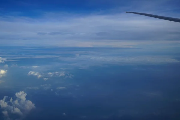 Latanie na płaszczyźnie widząc piękne odcienie barwione błękitne niebo horizon wschód i tło światło na biały obłok z skrzydła samolotu — Zdjęcie stockowe