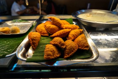 Bulanık insanlar arka plan ile muz yaprağı üzerinde lezzetli Hint tarzı köri puf dolu tepsi