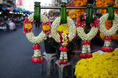 Güzel taze el yapımı çiçek çelenk satır beyaz gardenya ve taç çiçek yaptı ve sabah Pazar arka plan ile Tay tarzı pandan üzerinde asılı kırmızı gül yaprakları