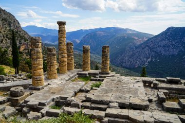 Eski harabe dünya mirası yeşil zeytin ağaçlarıyla Vadisi, Parnassos Dağı ve mavi gökyüzü arka plan ile Apollo Tapınağı, panoramik manzaralı