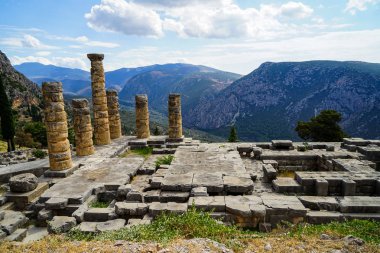 Eski harabe dünya mirası, Apollon Tapınağı yeşil zeytin ağaçlarıyla Vadisi, Parnassos Dağı ve mavi gökyüzü arka plan güzel görünümü