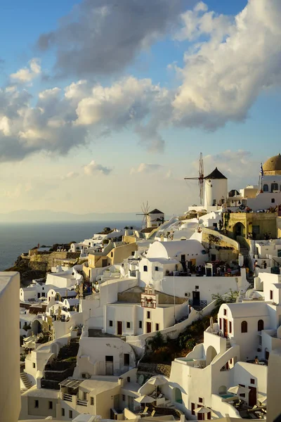 Beautiful evening light scene of Oia white building townscape along island mountain, Aegean sea, abstract cloud and blue sky background — Stock Photo, Image