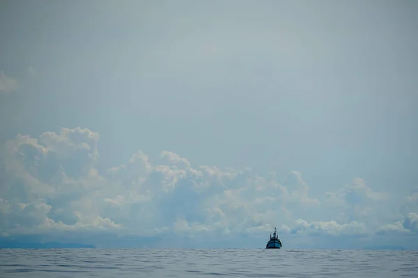 白い雲と青い空を背景に光の海波の広大な海で独立していないセーリング漁師モーター ボート — ストック写真